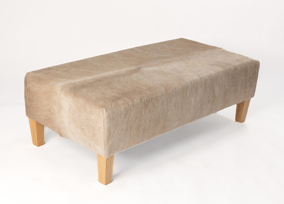 Beige cowhide ottoman with light wood legs