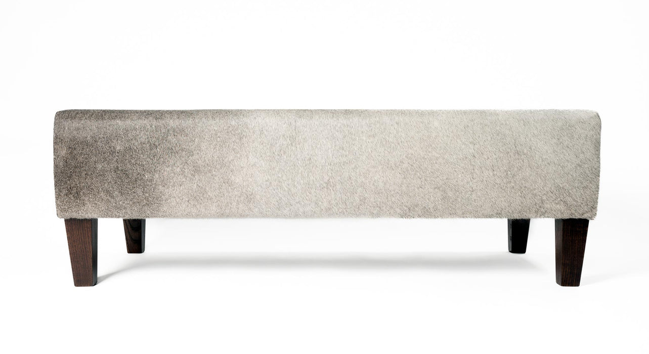 Grey cowhide ottoman with red brown wood legs