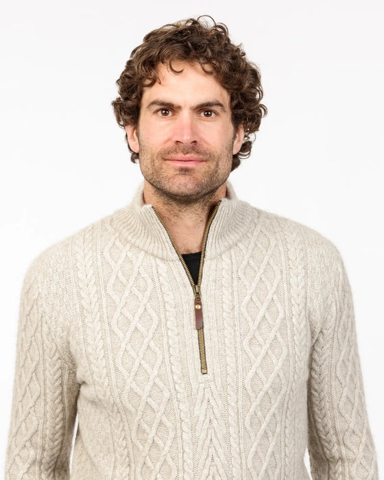 Man wearing a beige cable knit sweater with a zipper