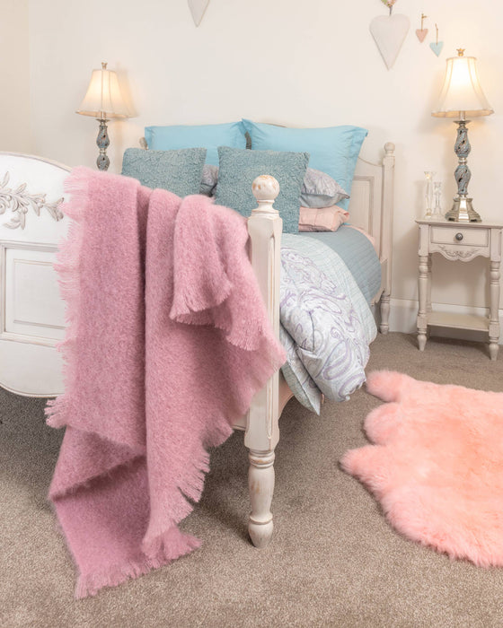 Peony pink mohair knee rug in a bedroom