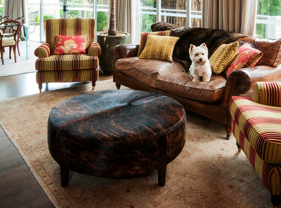 A dark brown exotic cow skin ottoman with wood legs 100cm x 100cm x 40cm tall.
