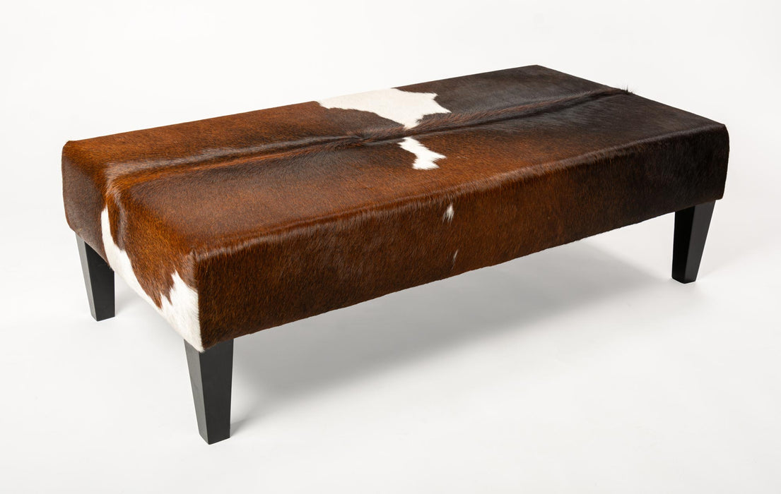 Reddish brown & white cowhide ottoman with wood legs 120cm x 60cm x 38cm tall.