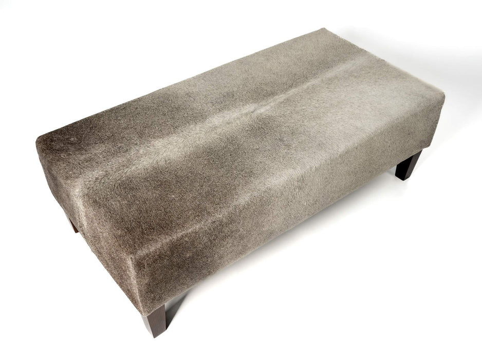 Grey cowhide ottoman with red brown wood legs