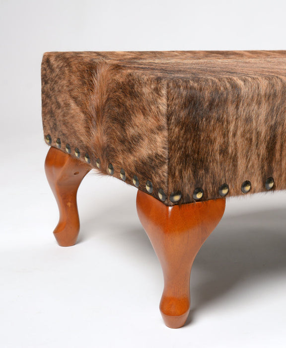 Cowhide ottoman with wood cabriole legs