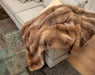 NZ Possum Fur Throw Honey Caramel on a sofa