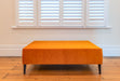 Bright orange velvet ottoman