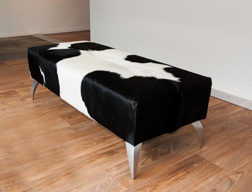 Black and white cowhide ottoman with metal legs