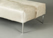 Natural off-white cow skin ottoman. A large rectangle with Stiletto metal legs.