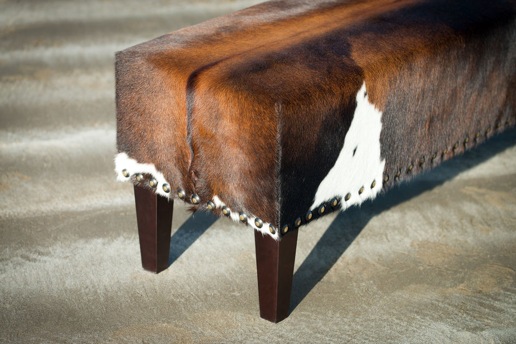 Cowhide ottoman with stud detail