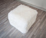 A cute white wool sheepskin footstool
